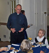 Pastor Gordon Smith conversing with members during dinner.