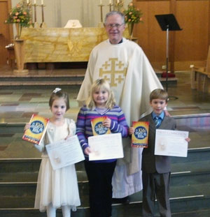 Pastor Elkin with Gabriella, Abbigail and Owen for first communion celebration